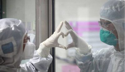 Dos médicos forman un corazón a través del vidrio en el hospital